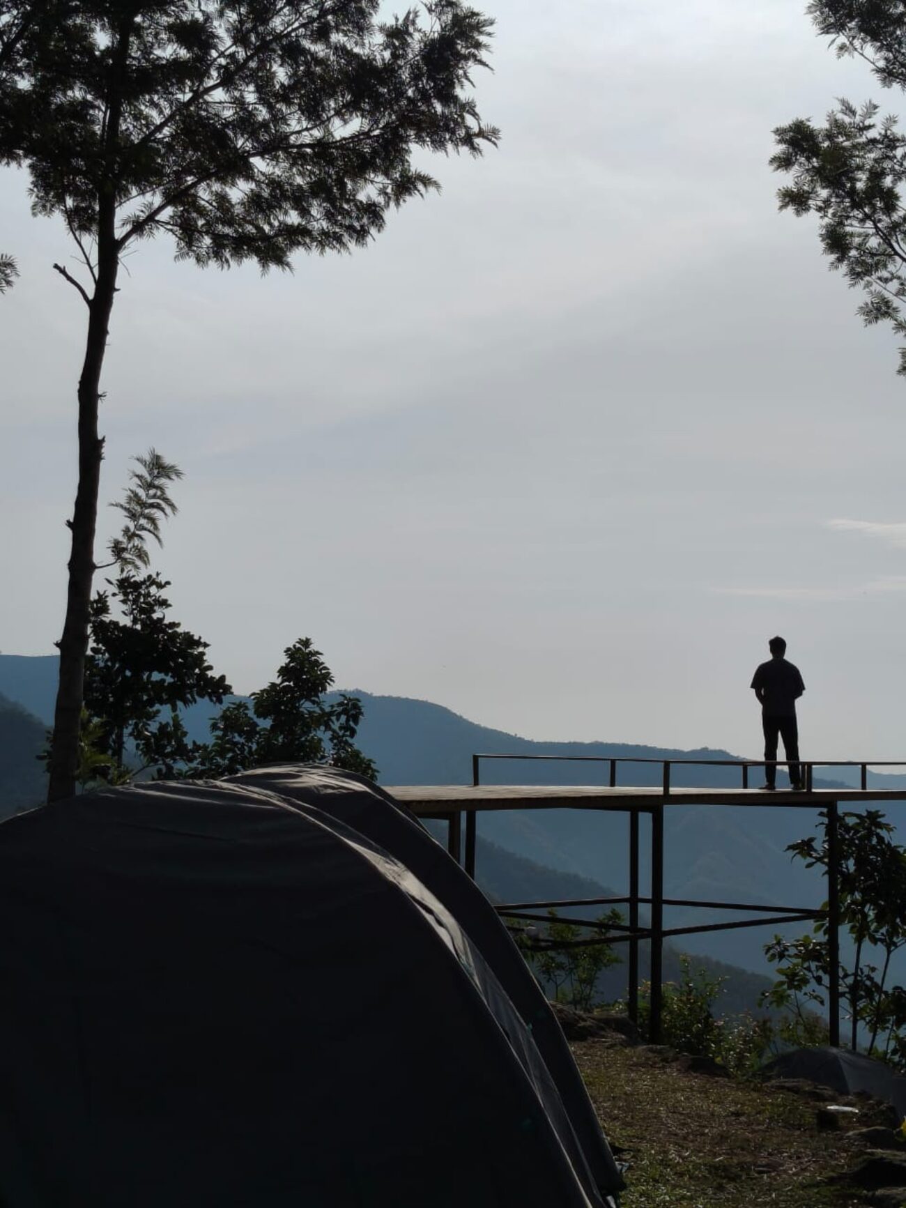 A lone camper on the viewing deck looking out over the hills
